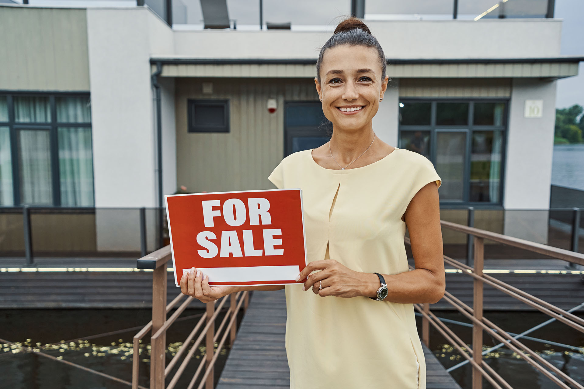 Happy person selling her house and smiling cheerfully