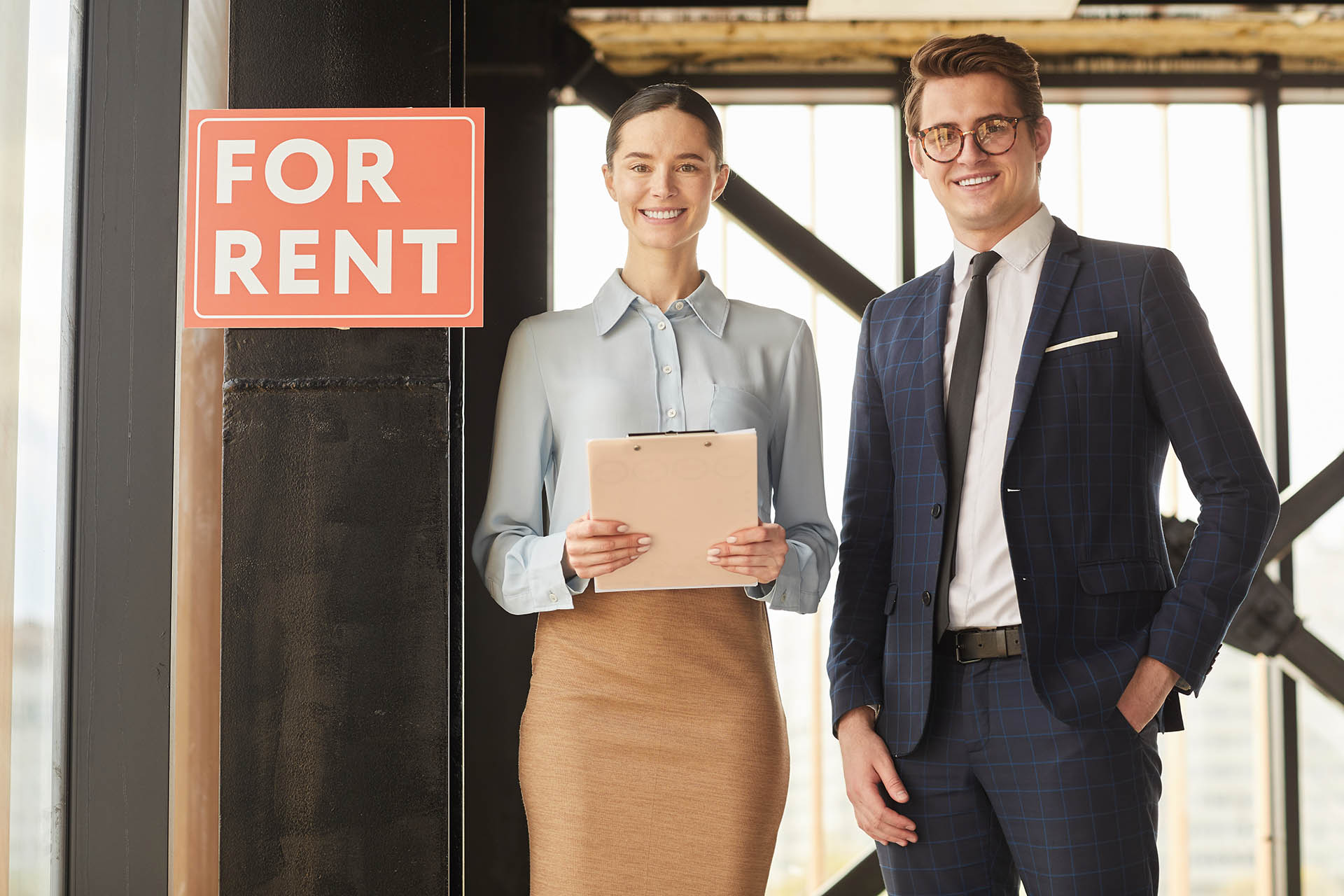 Real Estate Agents Standing by For Rent Sign